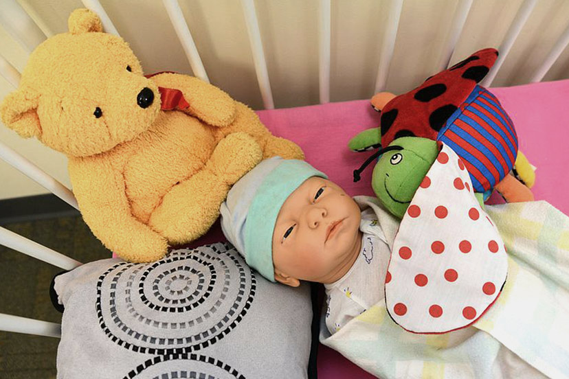 A doll lies in an unsafe infant sleeping environment at the Family Health Care clinic at the Joint Base Elmendorf-Richardson hospital, Alaska.&nbsp;Photo by Airman 1st Class Christopher Morales [Public domain], via Wikimedia Commons.